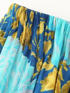 Close-up of pleated chiffon fabric featuring blue and yellow floral prints for tiered dress