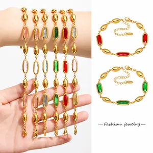 Dettaglio di bracciali con pietre preziose colorate dorate e chiusura a moschettone