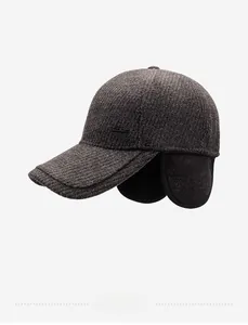 Detail view of winter baseball cap showing dark brown tweed texture and ear protection