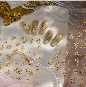 Macro shot of 3D gold flower nail stickers with vintage embossed floral design
