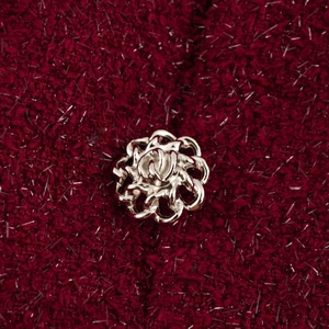 Détail de la robe en tweed rouge foncé avec fil argenté et bouton fleur de camélia