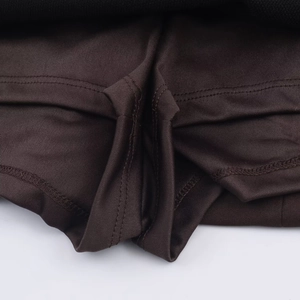 Detail view of double-stitched reinforced seams on breathable dark brown knitted fabric