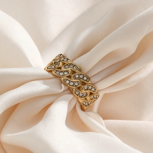 Gold-plated Cuban chain ring with shimmering cubic zirconia on soft silk background