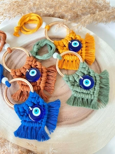Macro shot of colorful woven cotton evil eye charms in yellow, brown, blue, and green