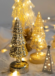 Luminous glass Christmas trees with warm LED lights and festive silver textures