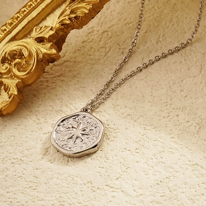 Collier avec pendentif étoile argentée à texture martelée irrégulière sur fond beige