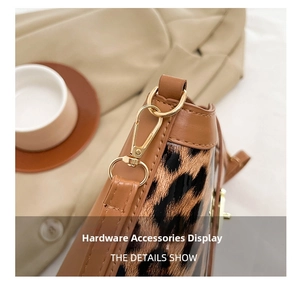 Detailed macro view of gold-tone metal hooks on a leopard print patchwork bucket bag