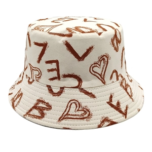 Detailed view of cream canvas bucket hat with brown heart graffiti and reinforced stitching