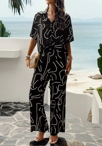 Outdoor shot of a two-piece set featuring short-sleeve shirt and wide-leg pants in black print