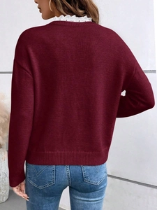 Detailed back view of a burgundy knit sweater with delicate white lace trim on the V-neck