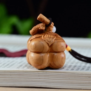 Macro shot of hand-carved wood persimmon pendant with natural grain on a book