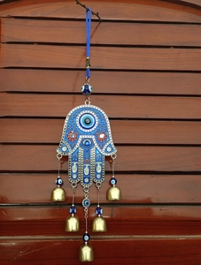 Detail of Hamsa Hand wind chime with blue evil eye beads and bronze-colored bells