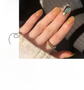 Details von kurzen runden Kunstnägeln in mattem Nude und metallischem Gold-Finish