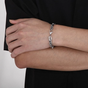Detail of silver rectangle link chain bracelet with lobster clasp on a wrist