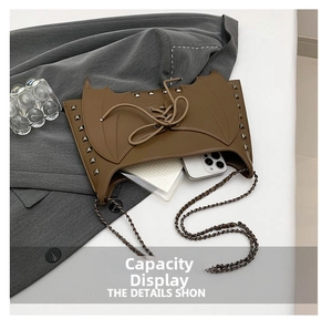 Vue détaillée du sac à bandoulière marron style aile de chauve-souris avec rivets métal.