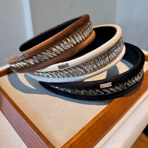 Détail de serre-têtes en velours avec cristaux en couleurs marron, blanc et noir