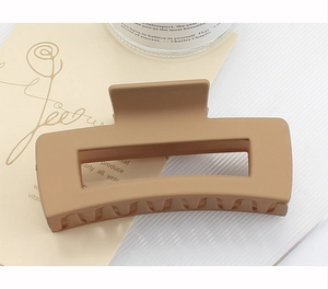 Macro shot of large square matte claw clip in camel brown for thick hair styling
