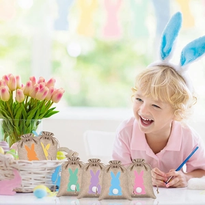 Detail of burlap Easter gift bags with colorful rabbit patterns and white fuzzy tails