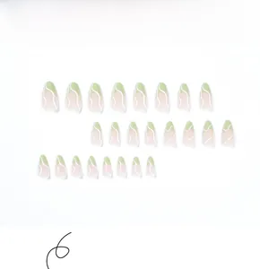 Detail view of almond shape press-on nails with green matte tips and white wavy lines