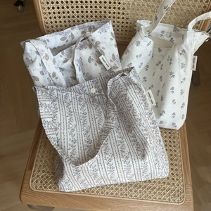 Detailed view of floral cotton tote bags with magnetic snaps and woven labels