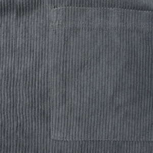 Close-up of grey corduroy fabric texture and precise pocket stitching on men shirt