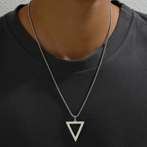Close-up of silver triangle pendant necklace on male model with dark gray t-shirt