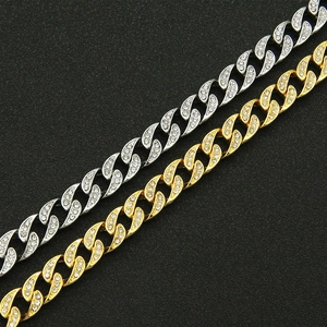 Close-up of gold and silver Cuban link chains with full rhinestone pave detailing