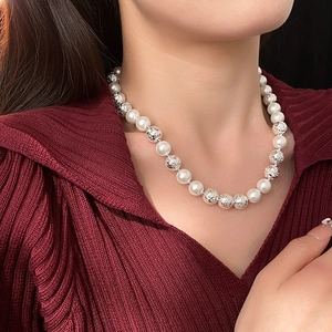 Detail of round white pearls and textured silver beads on a minimalist necklace