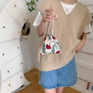 Detail view of floral cotton linen drawstring storage bag with red poppy print and brand label