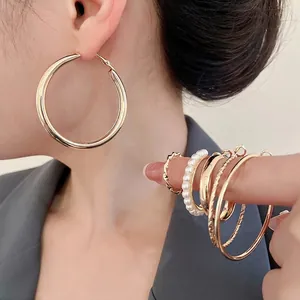 Elegantes Set aus goldenen Creolen und Perlenring an einem stilvollen Fashion-Modell