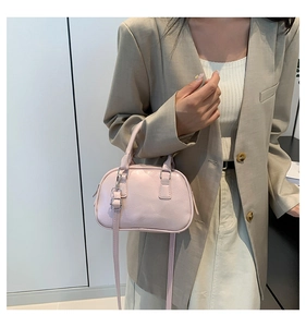 Detailed view of pink minimalist crossbody bag with top handles and silver hardware
