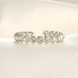Macro view of adjustable silver ring with micro-pave round zircons on silk