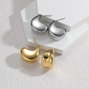 Minimalist wide dome stud earrings in gold and silver finish on stone display