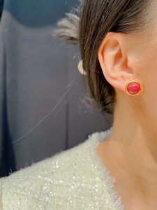 Gros plan sur des boucles d'oreilles vintage avec émail rouge et cadre doré poli