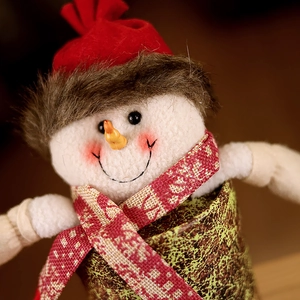 Close-up of a Christmas snowman plush jar with red knitted hat and warm fabric textures
