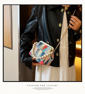 Detailed shot of retro geometric fabric doctor bag with pearl handle and metal chain strap