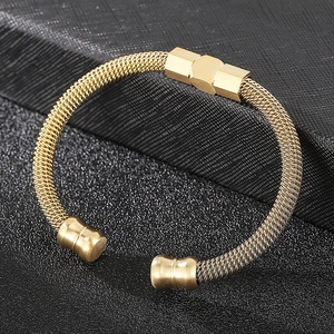 Détail macro du bracelet ouvert en maille de câble dorée avec fermoir hexagonal poli