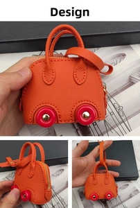 Detailed macro view of orange car-shaped mini bag with gold zipper and pink wheels