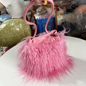 Gros plan du sac seau rose en fausse fourrure avec cordon et poignée en cuir PU