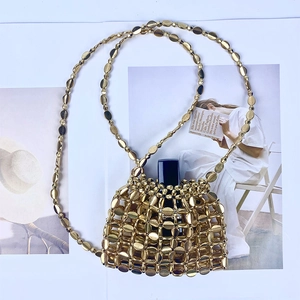 Detailed macro view of a gold metallic beaded mini bag with a lipstick inside for size reference