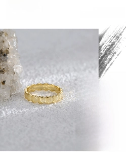 Detailed side view of a gold-toned scalloped ring with elegant brushed vertical textures