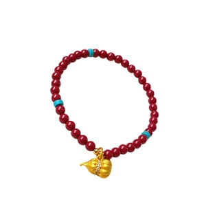 Red cinnabar beaded bracelet with turquoise accents and a gold-plated zircon gourd charm