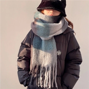Close-up of thick plaid tassel scarf with soft mohair texture in blue and grey tones