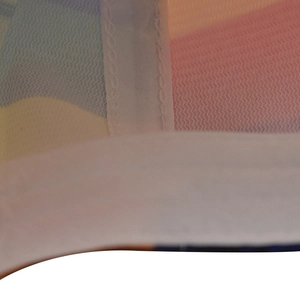 Close-up of rainbow gradient mesh fabric with white stitched edges on a baseball cap