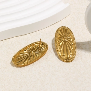 Nahaufnahme goldener ovaler Ohrstecker mit Relief-Blumendesign und Perlenrand-Struktur