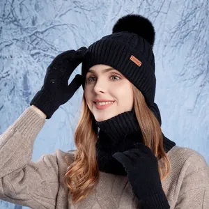 Women black winter knit set with pom-pom beanie scarf and gloves in snow scene