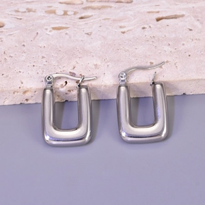 Close-up of silver hollow crescent earrings with polished finish and hinged closure