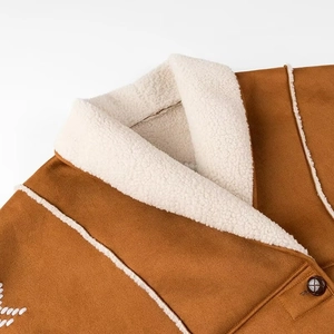 Close-up of brown faux suede jacket collar with white faux shearling trim and button