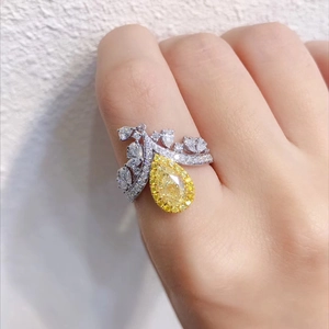 Detailed view of luxury crown ring featuring pear-cut yellow diamond on model's finger
