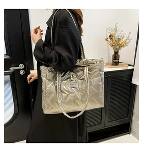Silver quilted down-filled tote bag shown on model highlighting its large capacity